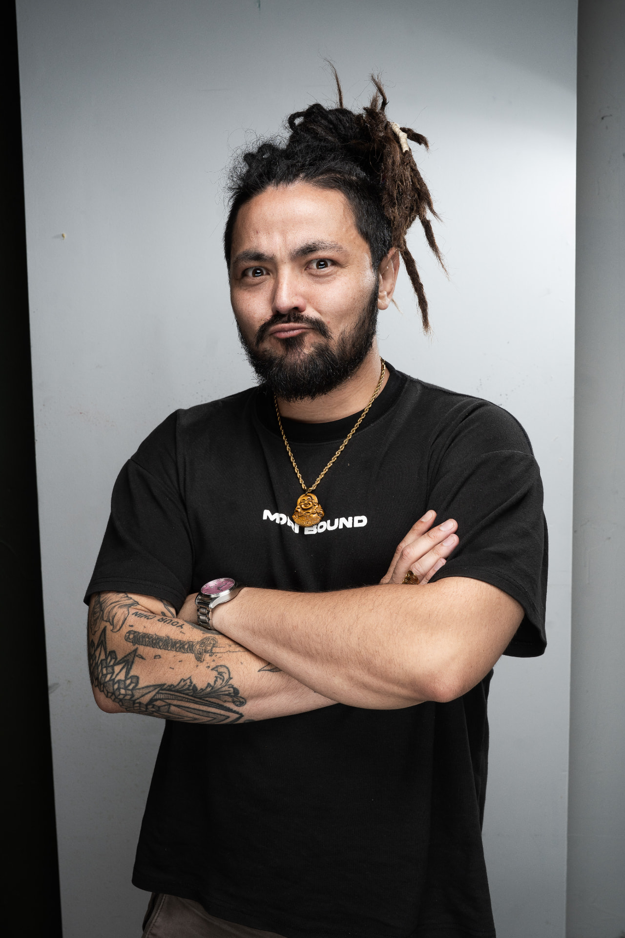 Matt Ayuen with his arms crossed in the approved right portrait